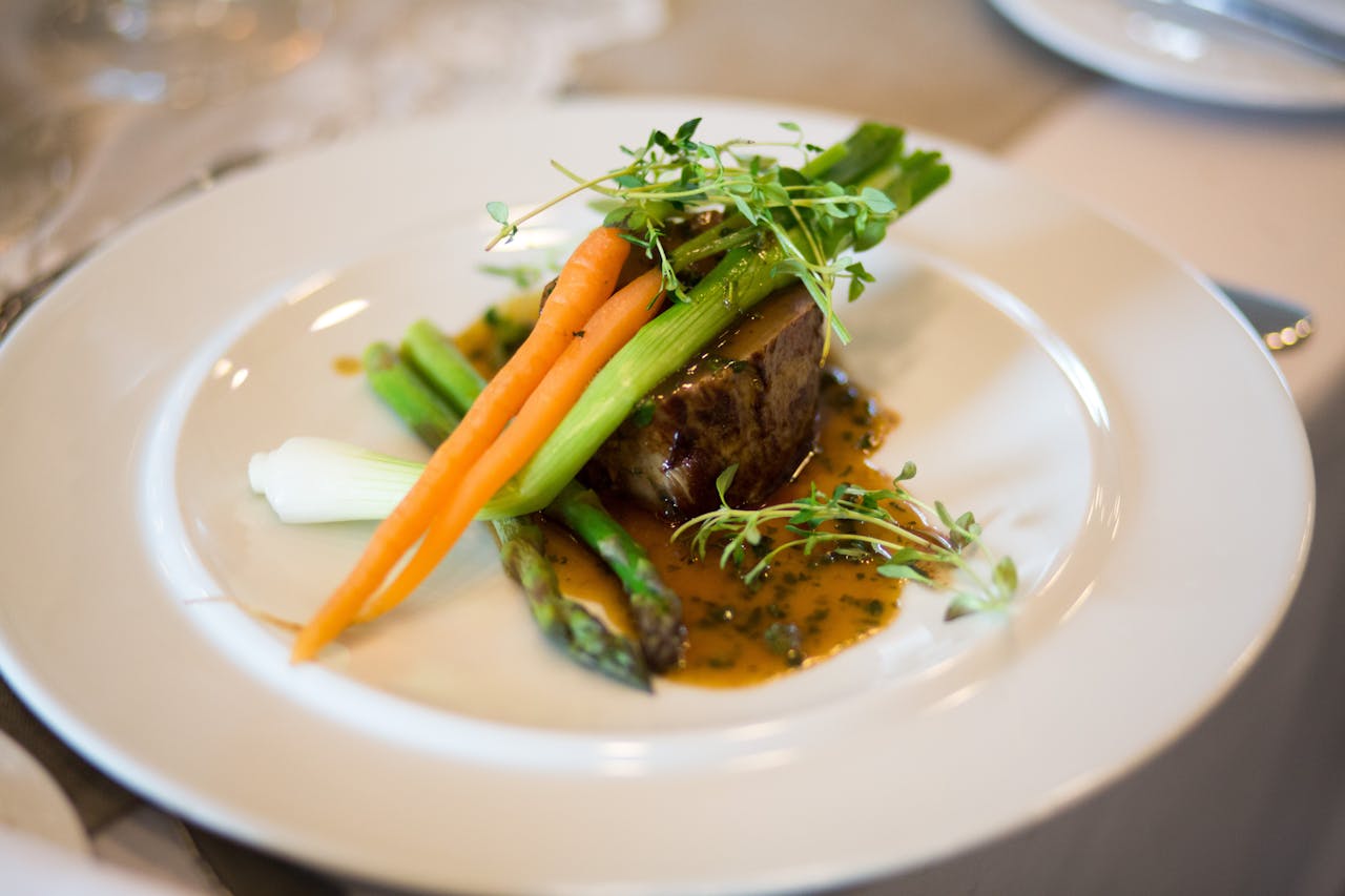 Luxurious gourmet meal elegantly plated with vegetables and sauce.